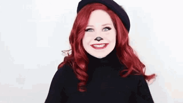 a woman with red hair is wearing a black turtleneck and a black beret and making a funny face .