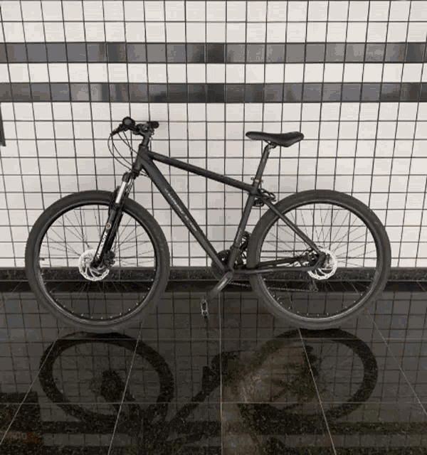 a black bicycle is parked on a tiled floor