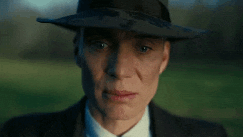 a close up of a man wearing a hat and suit