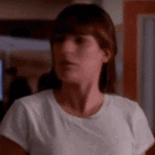 a woman in a white t-shirt is making a funny face .