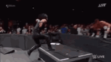 a man is flying through the air in front of a crowd of people at a concert .