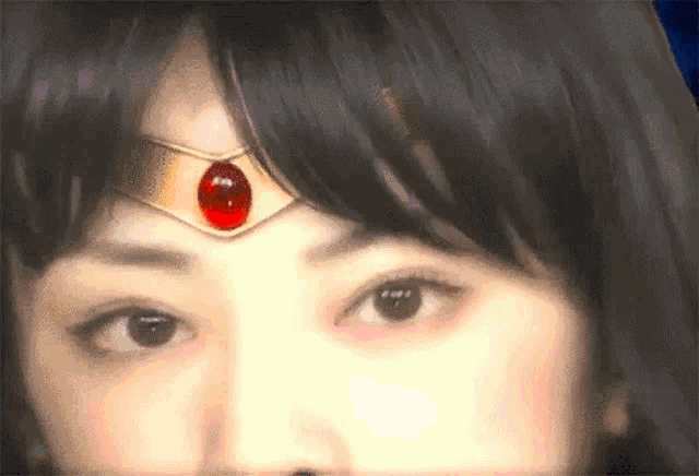 a close up of a woman 's face with a tiara on her head