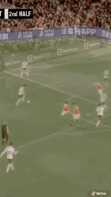 a soccer game is being played in front of a crowd with a banner that says app on it