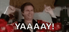 a man wearing red boxing gloves is raising his arms in the air and saying yaaaay .
