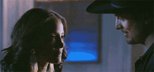 a man and a woman are looking at each other in the dark