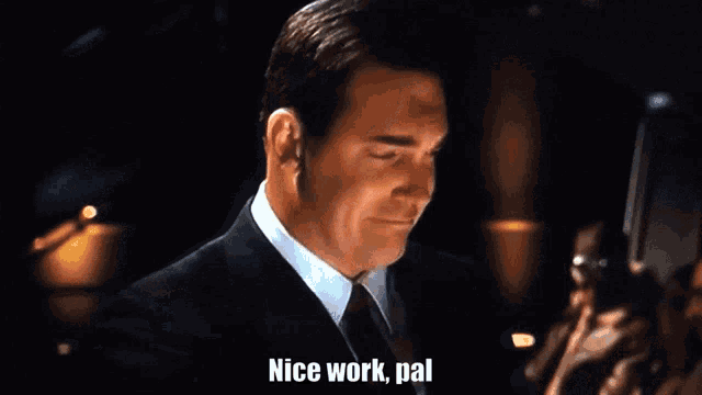a man in a suit and tie is saying " nice work pal "