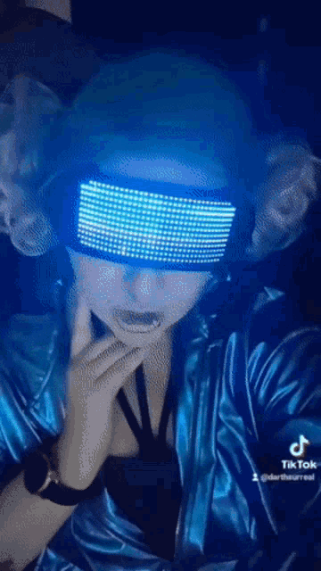 a person wearing a blue jacket and a pair of blue led glasses .