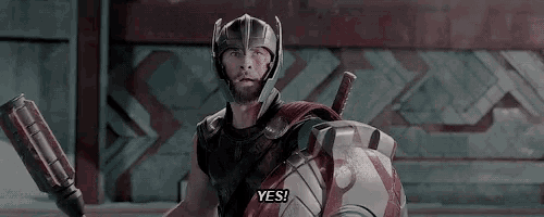 thor is wearing a helmet and holding a sword and shield and saying yes .