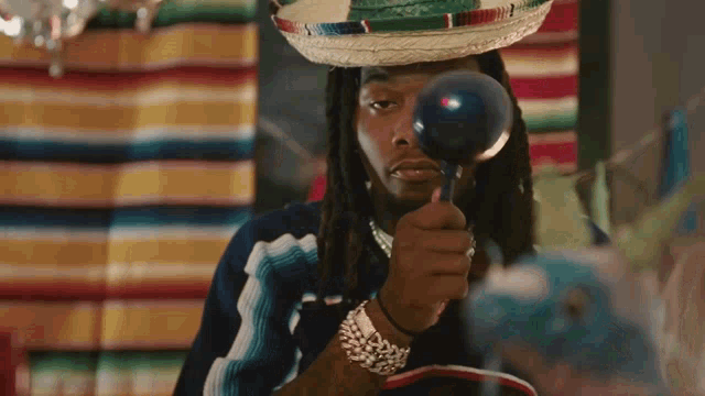 a man in a sombrero is holding a maraca