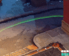 a green light is shining on a sidewalk in a video game .