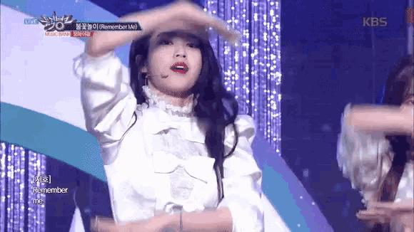 a woman in a white dress is dancing on stage .