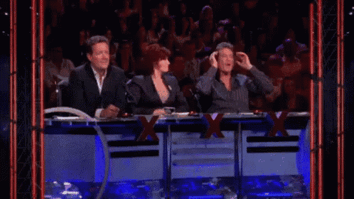 a group of people are sitting at a table with x on it