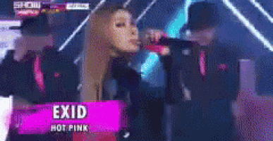 a woman is singing into a microphone with the name exid hot pink