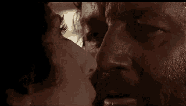 a close up of a man and woman kissing in a movie .