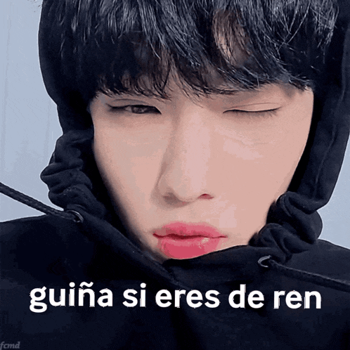 a close up of a person wearing a black hoodie with guiña si eres de ren written in white