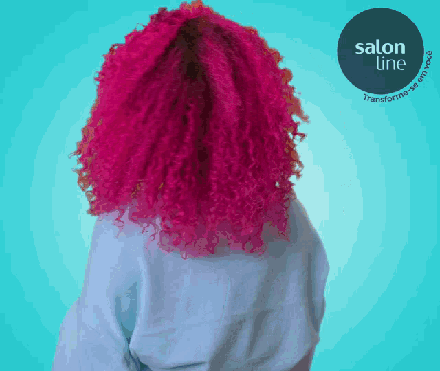a woman with pink curly hair stands in front of a blue background with a salon line logo