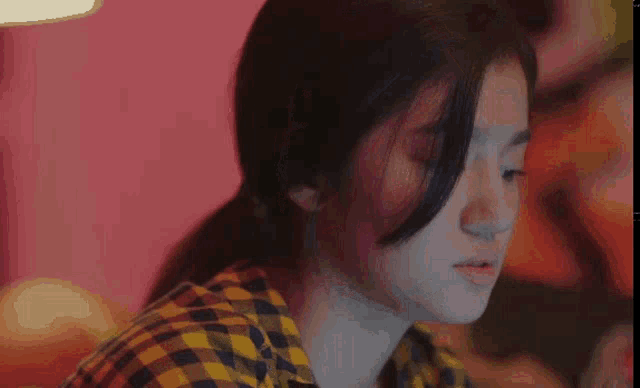a close up of a woman 's face in a pink room .