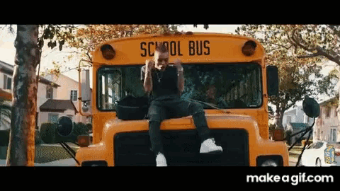 a man is sitting on top of a school bus