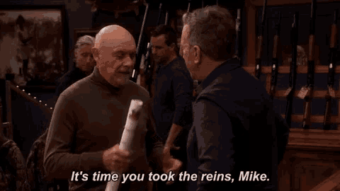 a man holding a piece of paper that says " it 's time you took the reins mike "