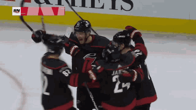 a hockey player with the number 24 on his jersey is surrounded by other players