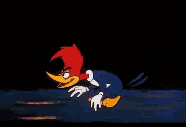 woody woodpecker is standing in the dark with his arms outstretched and his mouth open .