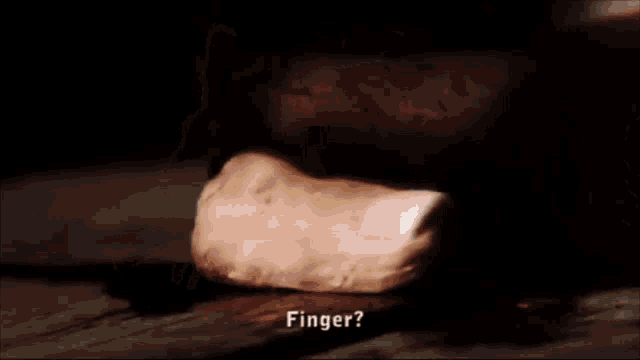 a close up of a person 's hand holding a piece of meat with the words finger written in the corner