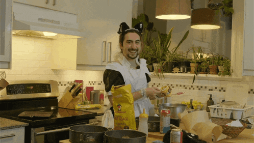 a man in a maid costume is cooking in a kitchen with a bag of beans on the counter