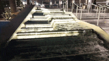 a waterfall in front of a building that says gf