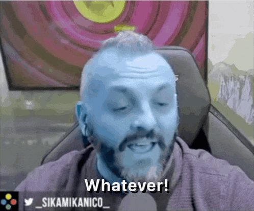 a man with blue hair says whatever in front of a screen