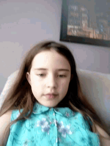 a young girl in a blue shirt is laying down