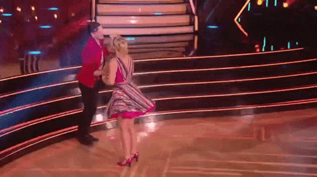 a man and a woman are dancing on a dance floor