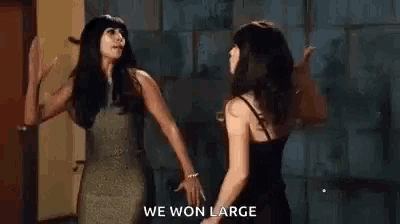 two women are standing next to each other and giving each other high fives .