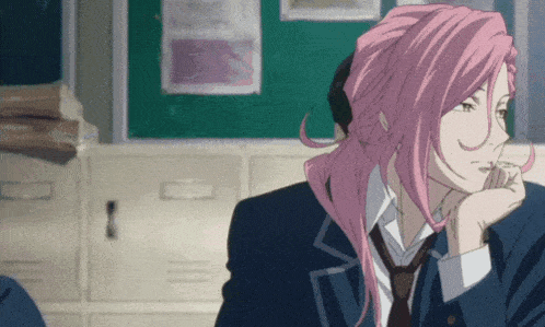 a girl with pink hair is sitting in a classroom