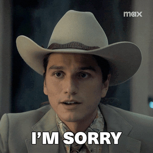 a man wearing a cowboy hat and a suit says i 'm sorry