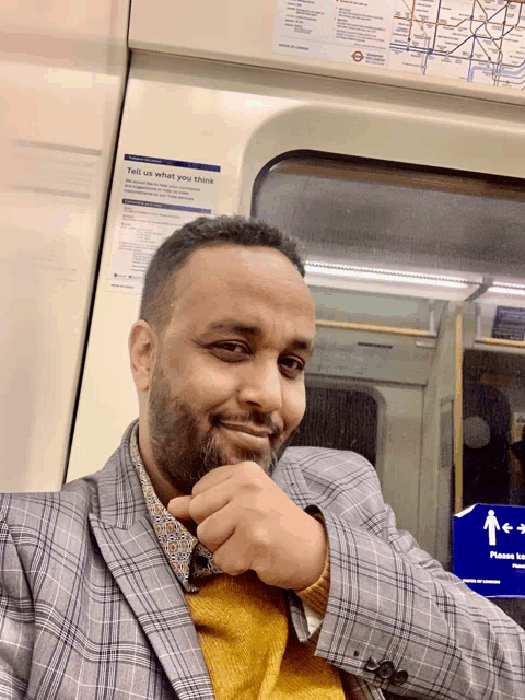 a man on a train with a sign that says tell us what you think on it