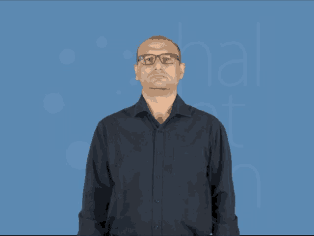 a man wearing glasses and a black shirt stands in front of a blue background that says hal