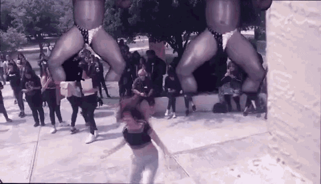a woman is dancing in front of a crowd of people wearing thongs .