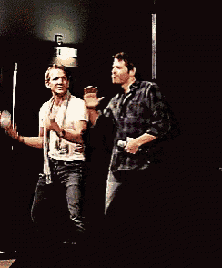 two men are dancing on a stage with a sign that says exit in the background