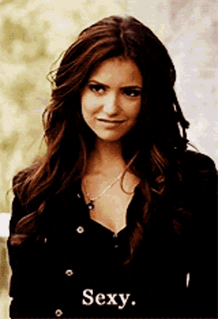 a woman with long brown hair is wearing a black shirt and necklace and the word sexy is on the bottom of the picture
