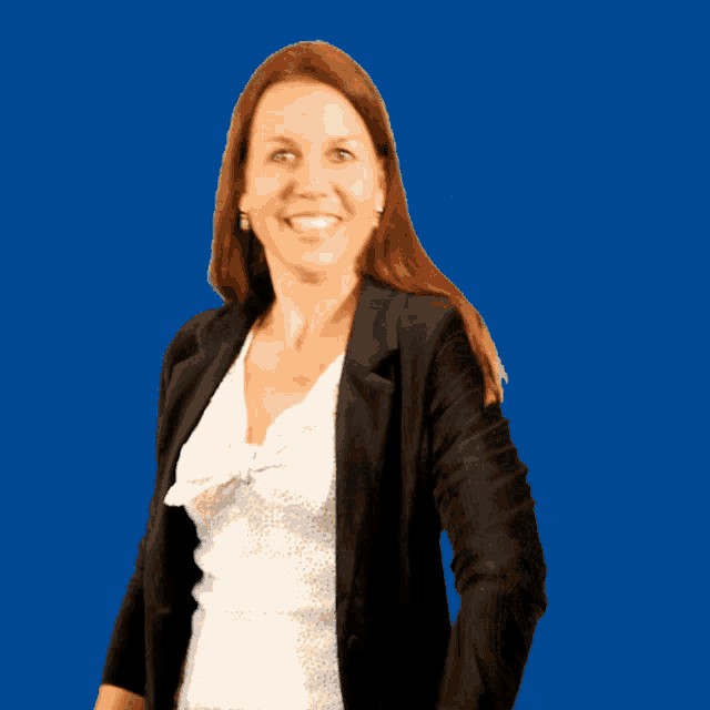 a woman wearing a black jacket and a white shirt is smiling