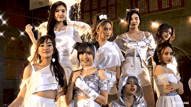 a group of young women are posing for a picture and one of them is wearing a white top