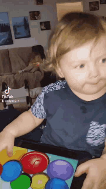 a little girl playing with a toy that has tiktok written on the bottom