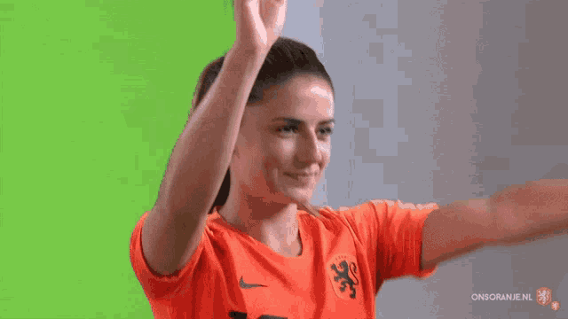 a woman wearing an orange nike shirt with a lion on the front