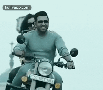 a man and a woman are riding on the back of a motorcycle .