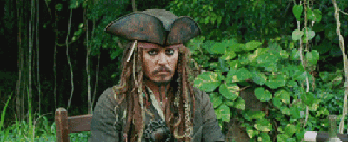 a man in a pirate costume is sitting in a chair in a forest .