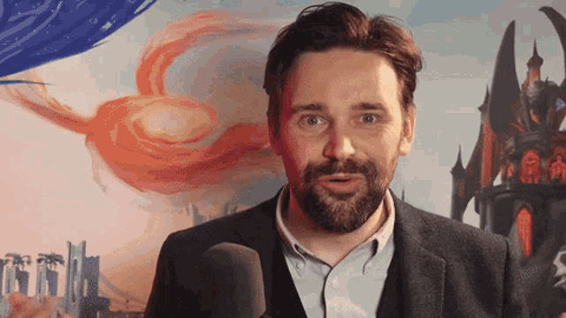 a man with a beard stands in front of a microphone