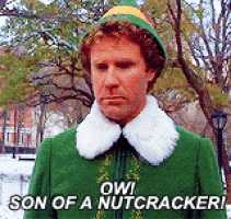 a man in a green elf costume is standing in a park .