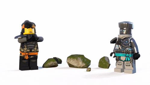 two lego figures are standing next to each other with a statue behind them