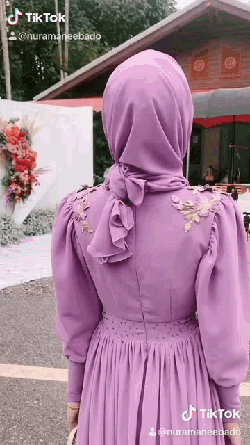 a woman wearing a purple dress and a hijab has a tiktok account
