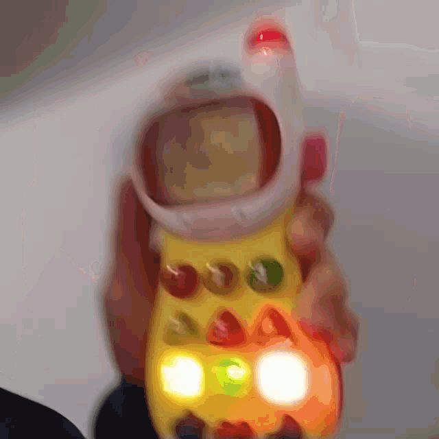 a person is holding a toy that looks like a cellphone